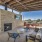 Outdoor shaded lounging with fireplace, outdoor kitchen, and TV's